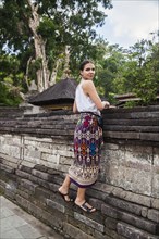 Woman climbing on stone wall