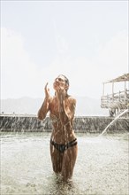 Woman splashing in pool outdoors