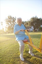Caucasian woman playing on seesaw in park