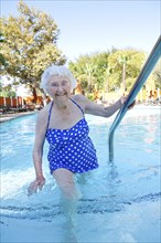 Older Caucasian woman walking in swimming pool