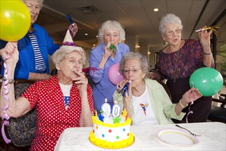 Older friends celebrating birthday in retirement home