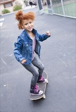 Girl riding skateboard in urban park