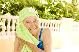 Older Caucasian woman drying with towel after swimming