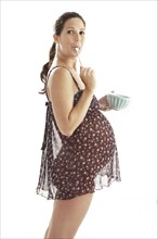 Side view of pregnant woman eating from bowl