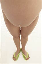 High angle view of belly of nude pregnant woman