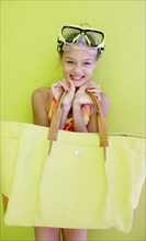 Caucasian teenage girl in goggles carrying beach bag