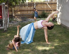 Mother and daughter dancing in backyard