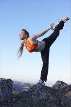 Caucasian woman practicing yoga on mountaintop