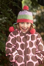 Smiling girl wearing hat and coat outdoors
