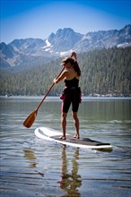 Mixed race woman on paddle board in Lake Tahoe