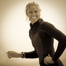 Smiling Caucasian woman wearing wetsuit