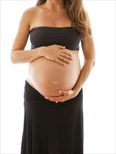 Close up of pregnant Caucasian woman holding belly