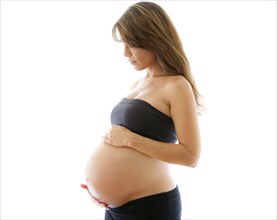 Close up of pregnant Caucasian woman holding belly