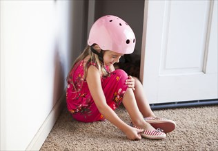 Caucasian girl wearing bike helmet in doorway