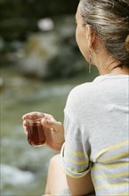 Rear view of woman drinking cocktail outdoors