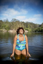 African American woman standing in rural lake