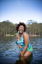 African American woman standing in rural lake