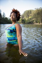 African American woman standing in rural lake