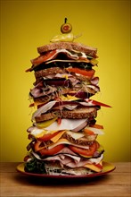 Oversized stacked deli sandwich on plate