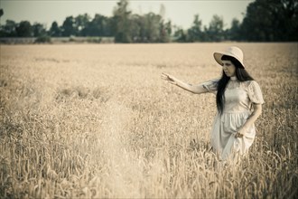 Woman walking in tall grass in rural field