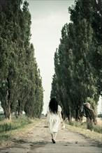 Woman walking on dirt road