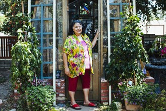 Hispanic woman smiling near garden greenhouse