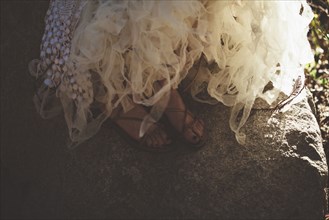 Close up of feet of bride wearing wedding gown and sandals