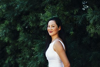 Korean bride smiling under trees