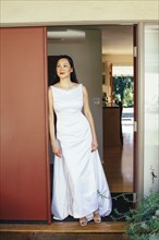 Korean bride wearing wedding dress in doorway
