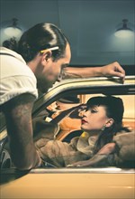 Glamorous couple talking in vintage car