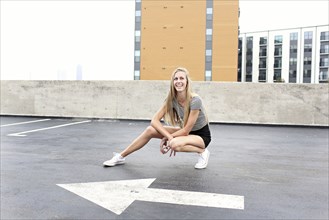 Teenage girl posing on urban rooftop parking lot