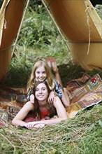 Sisters laying in camping tent