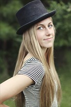 Smiling woman wearing top hat outdoors