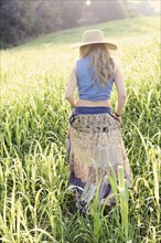 Teenage girl walking in tall grass