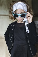 Serious girl peering over sunglasses