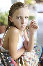 Close up of serious girl sitting on porch