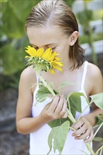 Close up of girl smelling sunflower outdoors