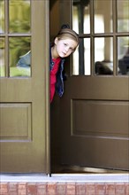 Curious girl standing in doorway