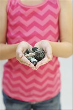 Close up of girl holding handful of stones