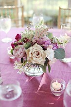 Bouquet of flowers in vase on pink tablecloth