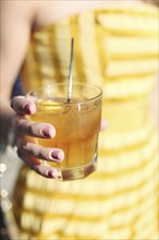 Close up of woman holding yellow cocktail drink