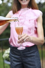 Woman pouring glass of rose wine