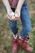 Caucasian girl holding chicken eggs on farm