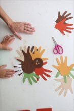 Students and teacher making Thanksgiving turkey crafts in classroom