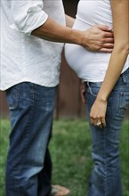 Close up of man hugging pregnant wife in backyard