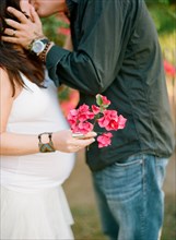 Man kissing pregnant wife outdoors