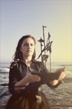 Woman holding model ship on beach