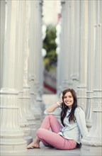 Smiling woman sitting between columns