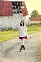Girl walking on dirt path in rural farm