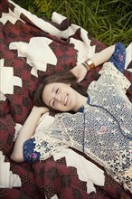 Girl laying on blanket in grass